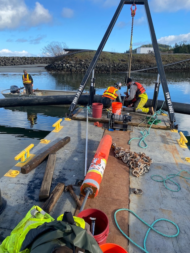 Photo of crew members attaching a dredging pipe