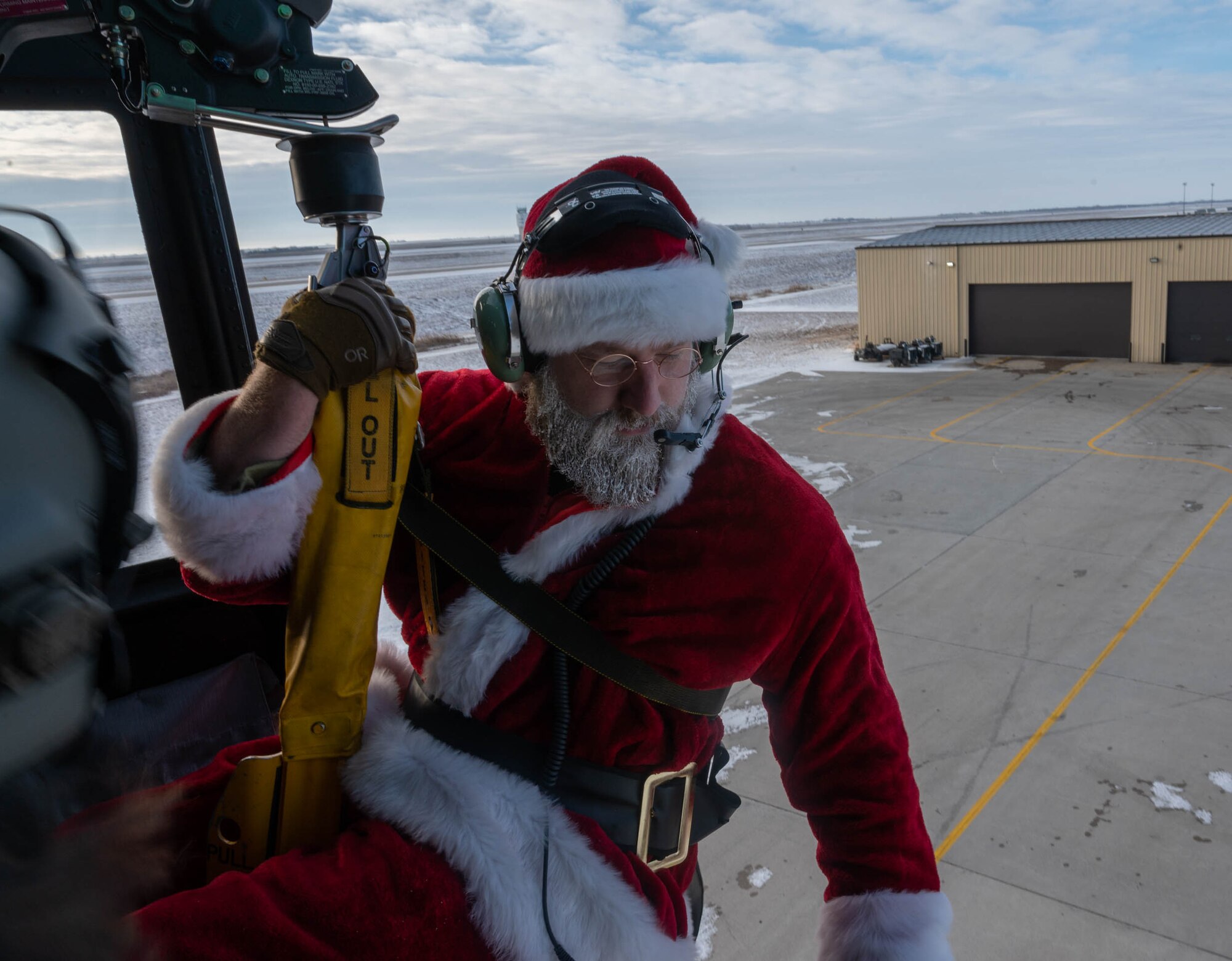 Santa Claus prepares to lower to an awaiting crowd at Minot Air Force Base, North Dakota on December 10, 2023. After waving to families throughout Minot, N.D. and Minot Air Force Base, Claus ends the day with a grand entrance to the 54th Helicopter Squadron holiday party. (U.S. Air Force photo by A1C Luis Gomez)