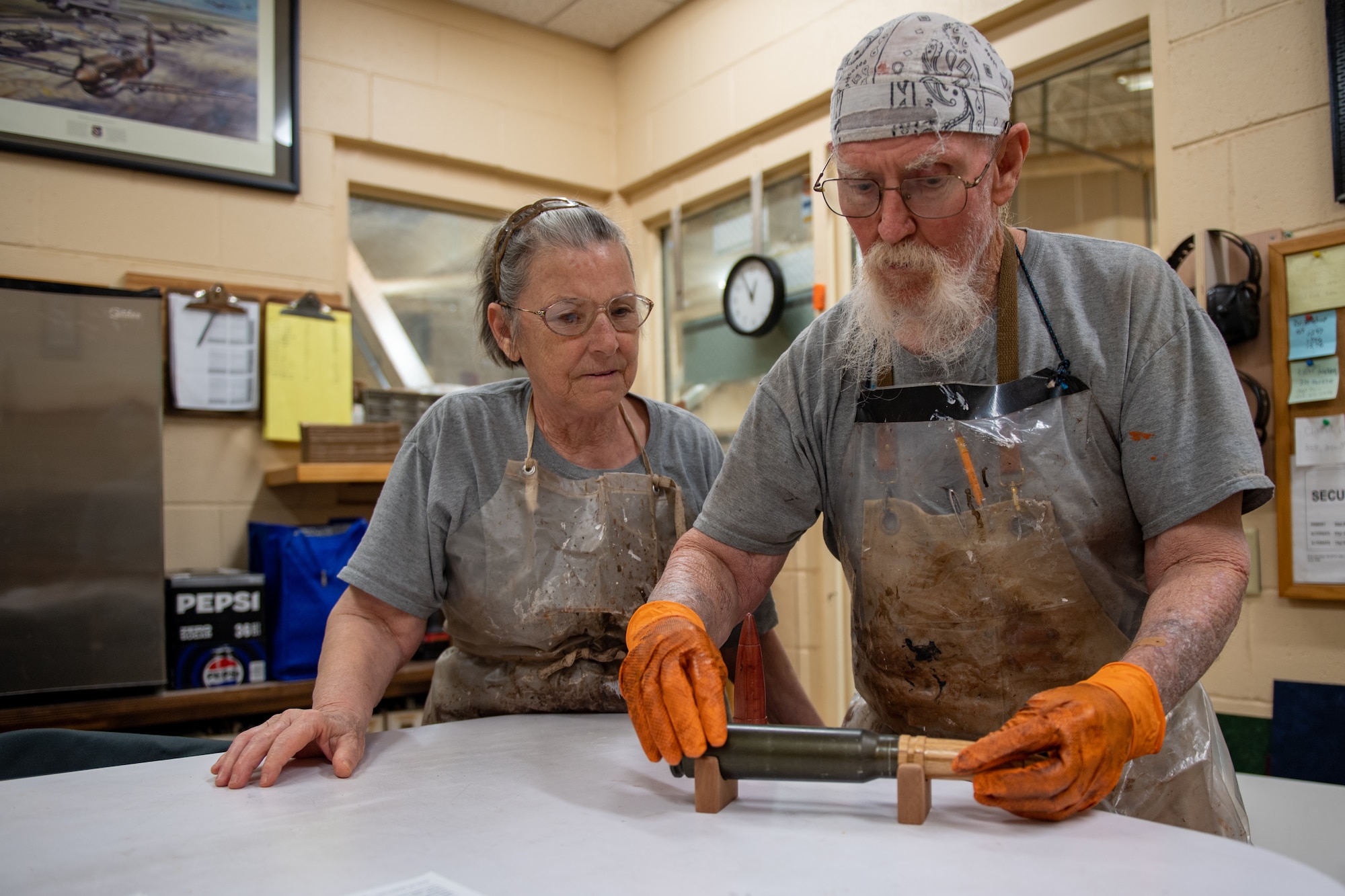 John Fischbach Sr., 23rd Force Support Squadron recreation aid, and Gail Fischbach, 23rd FSS recreation woodshop volunteer, place a customA-10 bullet casing into a wooden stand in the woodshop at Moody Air Force Base, Georgia, Nov. 28, 2023. The woodshop is available for military members to use at their convenience. (U.S. Air Force photo by Senior Airman Courtney Sebastianelli)