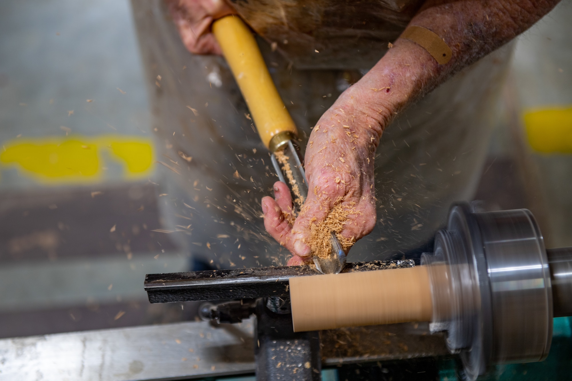 John Fischbach Sr., 23rd Force Support Squadron recreation aid, shaves a block of wood into the shape of an A-10 30mm shell tip at Moody Air Force Base, Georgia, Nov. 28, 2023. After Fischbach shapes the piece of wood he will attach it to an empty A-10 30mm shell casing. (U.S. Air Force photo by Senior Airman Courtney Sebastianelli)