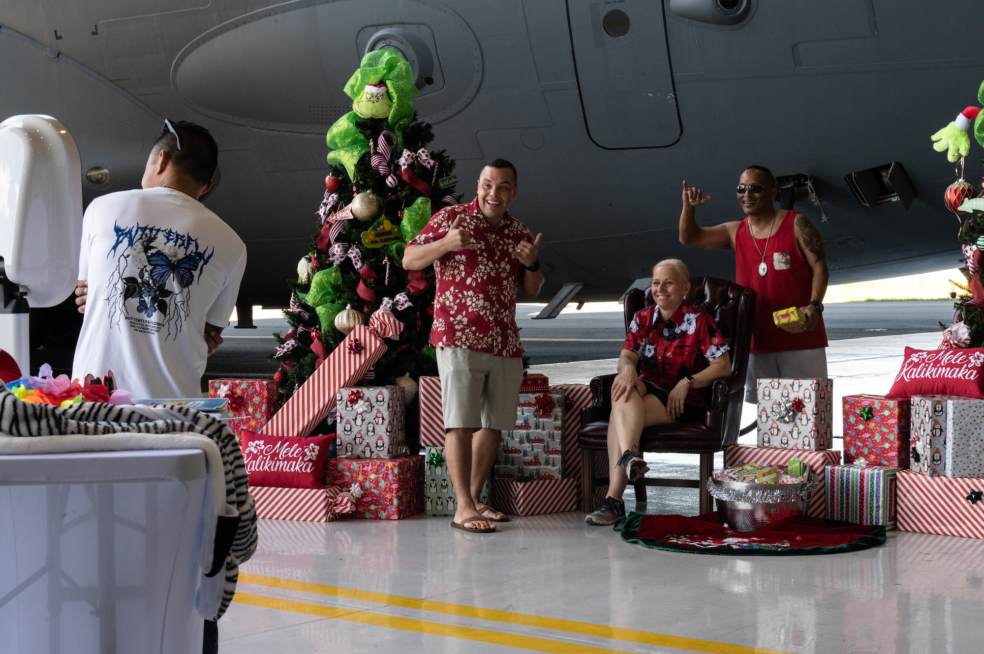 Col. Andrew Garcia, 15th Maintenance Group commander, Col. Michele Lo Bianco, 15th Wing commander, and Peter Cruz, 15th Wing protocol chief, pose for a photo during the 15th Wing Keiki Holiday Party at Joint Base Pearl Harbor-Hickam, Hawaii, Dec. 9, 2023. Military children were able to take photos with Santa in the fuselage of the C-17 Globemaster III. (U.S. Air Force photo by Staff Sgt. Alan Ricker)