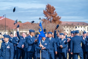 U.S. Air Force and U.S. Space Force newly commissioned officers celebrating after Officer Training School Victory graduation, December 8, 2023, at Welch Field, Maxwell Air Force Base, Alabama. Newly commissioned officers throw there covers in the air after graduating OTS. (U.S. Air Force photo by Airman Tyrique Barquet)