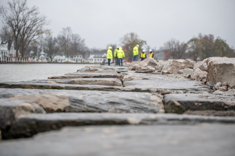 Photo of the newly laid stone used to repair the pier as USACE Buffalo District teammates and contractors inspect the repairs.