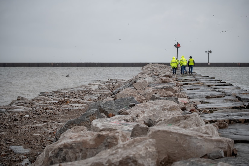 Photo of the newly laid stone used to repair the pier as USACE Buffalo District teammates and contractors inspect the repairs.