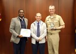 Naval Surface Warfare Center, Philadelphia Division (NSWCPD) Technical Director Nigel C. Thijs, SES, and Commanding Officer Capt. Joseph Darcy present the Navy Civilian Service Commendation Medal to Joseph Hungerbuhler for his superior performance while serving as a mechanical engineer at NSWCPD. The command honored employees during its Fiscal Year (FY) 2023 Fourth Quarter Awards Ceremony on Nov. 28, 2023. (U.S. Navy Photo by Phil Scaringi/Released)