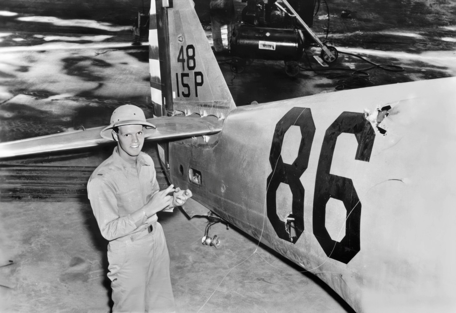 2nd Lt. Philip M. Rasmussen was part of Lt. Sanders’ formation that attacked Japanese Zeros in a major dogfight that showed that American forces were finally able to confront the raiders in force. In this photo, he is pointing to various bullet holes in his P-36A from the Zeros. Some of the holes are from the Zeros’ wing-mounted 20mm cannon. Rasmussen also received the Silver Star. He and Sanders each claimed one Zero.