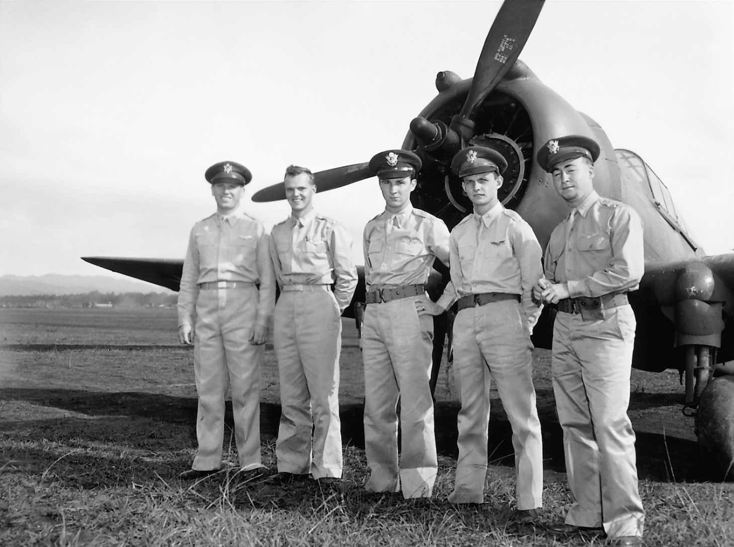 A post-raid lineup of some of the Army aviators who chased the departing Japanese raiders and shot a few down. They pose in front of the P-36A that 2nd Lt. Harry W. Brown flew. From left to right: P-36 pilots 1st Lt. Lewis M. Sanders and 2nd Lt. Philip M. Rasmussen, each pilot got one Zero, P-40B pilots 2nd Lts. Ken Taylor and George Welch, together, scored six confirmed kills (Welch with four and Taylor with two, although post-war research added two more to Taylor’s total on Dec. 7).