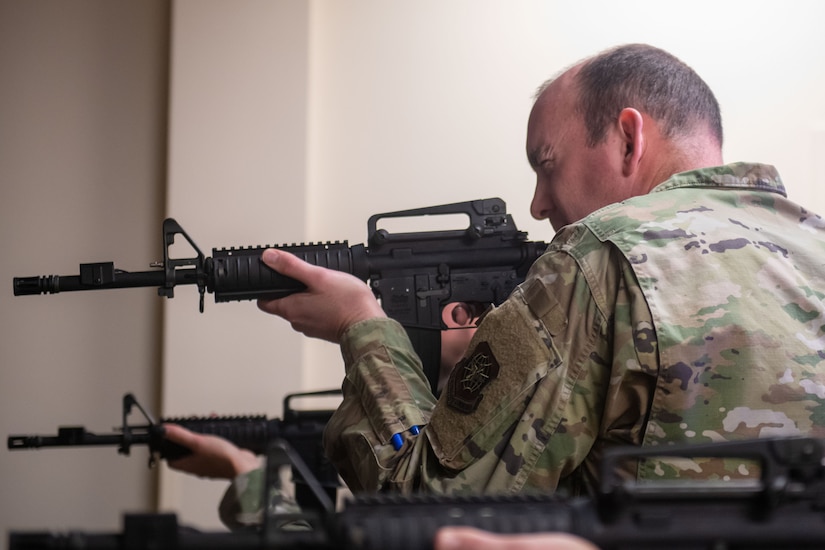 U.S. Air Force Col. Michael Freeman, 628th Air Base Wing and Joint Base Charleston commander, focuses on a target during firearms simulator training at JB Charleston, South Carolina, Dec. 7, 2023.