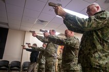 Joint Base Charleston leadership fire M-9 pistols at simulated targets during firearms simulator training at Joint Base Charleston, South Carolina, Dec. 7, 2023.