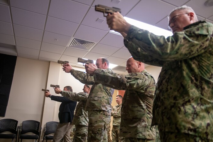 Joint Base Charleston leadership fire M-9 pistols at simulated targets during firearms simulator training at Joint Base Charleston, South Carolina, Dec. 7, 2023.