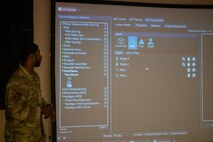 U.S. Air Force Tech. Sgt. Kourtlyn Stafford, 628th Security Forces Squadron training non-commissioned officer in charge, explains the nuances of the firearms training simulator system at Joint Base Charleston, South Carolina, Dec. 7, 2023.