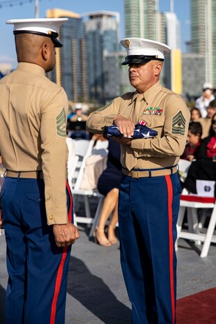 U.S. Marine Corps 1st Sgt. Christian Fuentes, Company First Sergeant with Third Recruit Training Battalion, Marine Corps Recruit Depot San Diego receives the colors during his retirement ceremony aboard the USS Midway (CV-41) Museum, San Diego, Dec. 7, 2023. Fuentes retired after 21 years of faithful service and held his retirement ceremony on the remembrance day of Pearl Harbor, to commemorate and honor the fallen service members. (U.S. Marine Corps photo by Sgt. Yvonna Guyette)