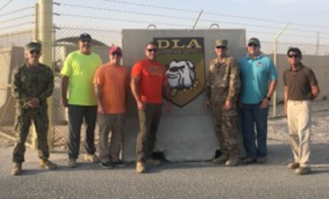 Group pose next to sign