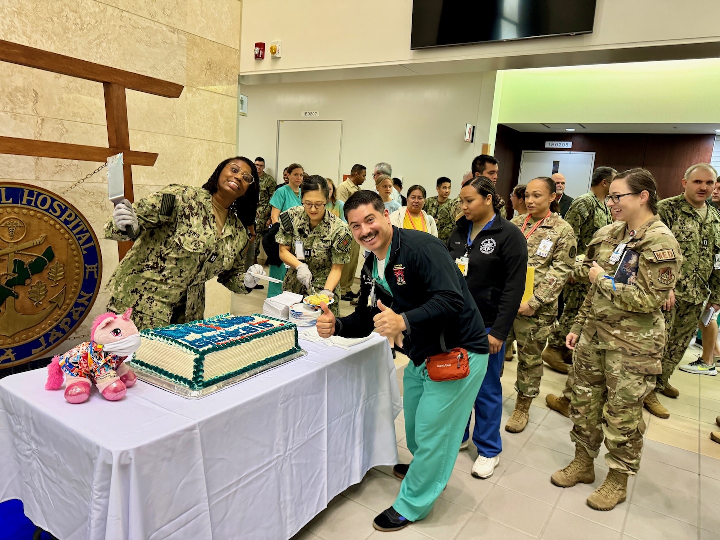 Sailors from USNMRTC Okinawa enjoys cake the morning of the MHS GENESIS launch.