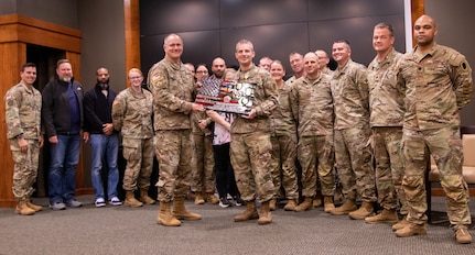 The G-3 staff presents Chief Warrant Officer 2 Peter E. Warren, Jr., with a retirement gift during a ceremony Dec. 8 at Camp Lincoln, Springfield, Illinois.