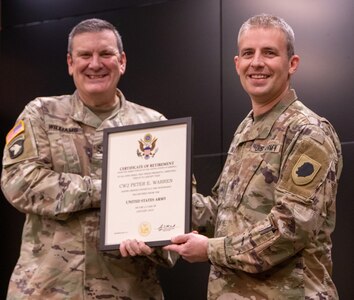 Col. Lenny Williams, Illinois Army National Guard Chief of Staff, presents Chief Warrant Officer 2 Peter E. Warren, Jr., with a certificate of retirement during a ceremony Dec. 8 at Camp Lincoln, Springfield, Illinois. Warren retired after 24 years of service in the Illinois National Guard.