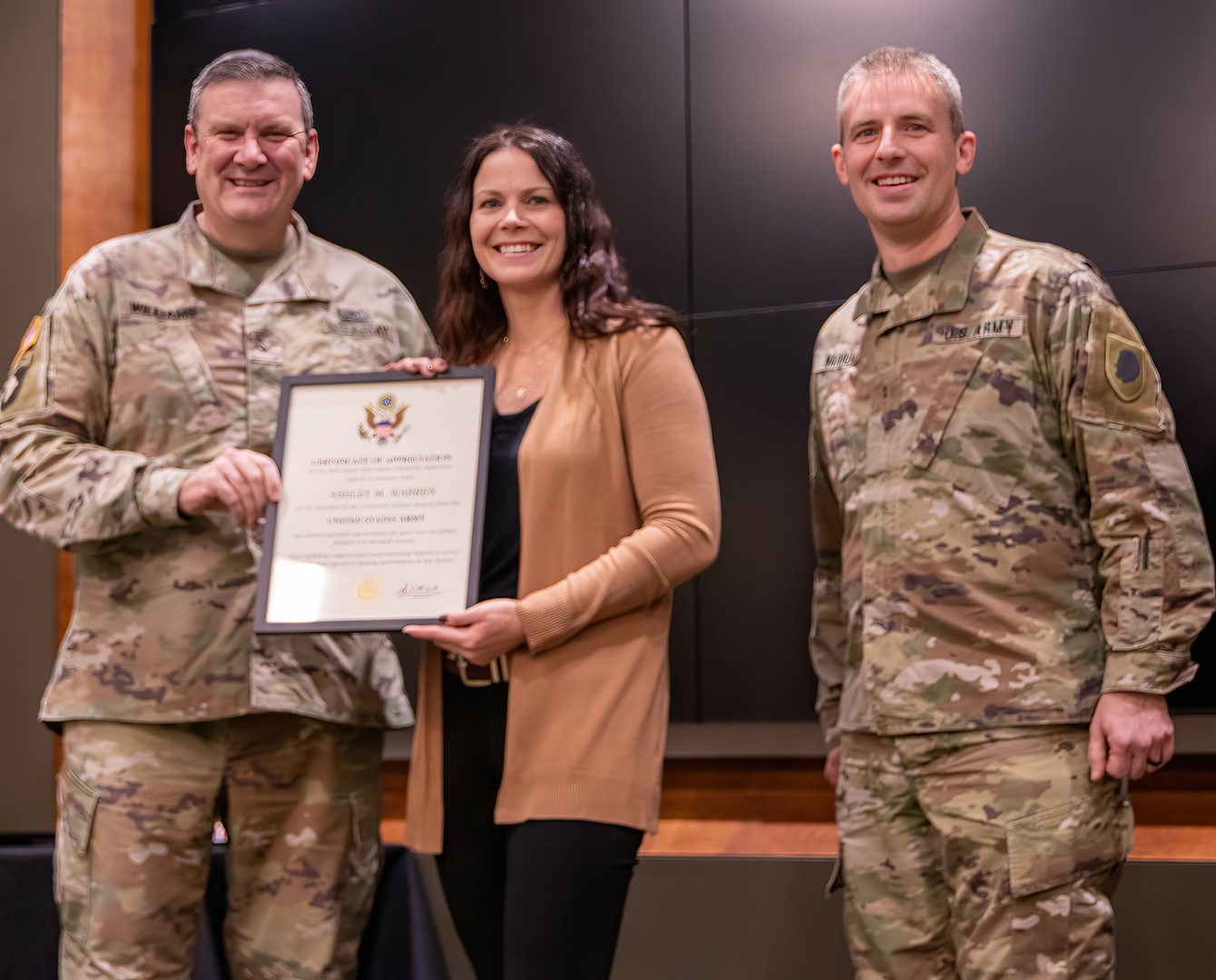 Col. Lenny Williams, Illinois Army National Guard Chief of Staff, presents Ashley Warren, wife of Chief Warrant Officer 2 Peter E. Warren, Jr., with a certificate of appreciation during a ceremony Dec. 8 at Camp Lincoln, Springfield, Illinois.