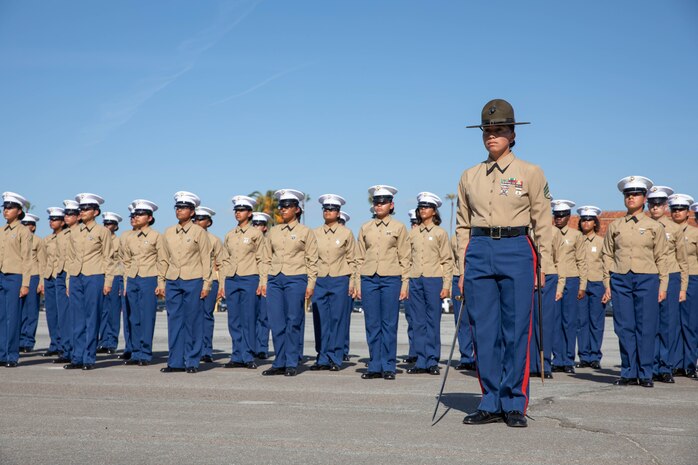 A  U.S. Marine Corps drill instructor with Charlie Company 1st Recruit Training Battalion, stands in formation in front of her platoon during a graduation ceremony at Marine Corps Recruit Depot San Diego, Dec. 8, 2023. Graduation took place at the completion of the 13-week transformation, which included training for drill, marksmanship, basic combat skills, and Marine Corps customs and traditions. (U.S. Marine Corps photo by Lance Cpl. Sarah M. Grawcock)