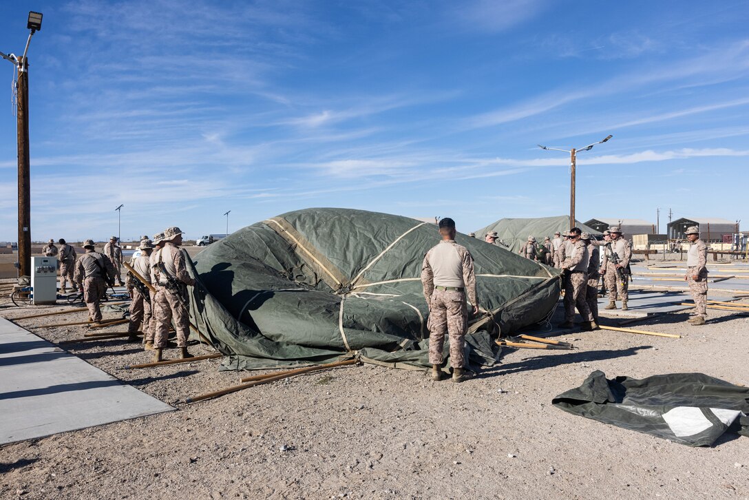 U.S. Marines with 5th Marine Regiment, 1st Marine Division, set up a tent for a mission rehearsal exercise during Steel Knight 23.2 at Yuma Proving Grounds, Arizona, Nov. 27, 2023. Steel Knight maintains and sharpens I Marine Expeditionary Force as America’s expeditionary force in readiness – organized, trained and equipped to respond to any crisis, anytime, anywhere. The exercise will certify 5th Marines to be forward-postured in Australia as Marine Rotational Force - Darwin, a six-month deployment during which Marines train with Australian allies and facilitate rapid response to crises and contingencies. (U.S. Marine Corps photo by Lance Cpl. Juan Torres)