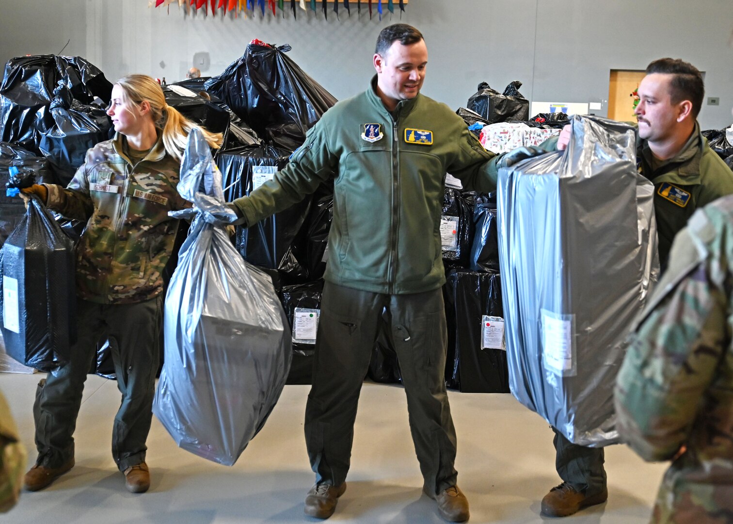 From left, Airman 1st Class Emma Schmidt, Master Sgt. Jay Inglis and Staff Sgt. Matt Dawley of the 133rd Air Refueling Squadron, 157th Air Refueling Wing, New Hampshire Air National Guard, load donated Christmas gifts onto a delivery truck Dec. 12, 2023, at the state military reservation in Concord.
