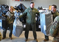 From left, Airman 1st Class Emma Schmidt, Master Sgt. Jay Inglis and Staff Sgt. Matt Dawley of the 133rd Air Refueling Squadron, 157th Air Refueling Wing, New Hampshire Air National Guard, load donated Christmas gifts onto a delivery truck Dec. 12, 2023, at the state military reservation in Concord.