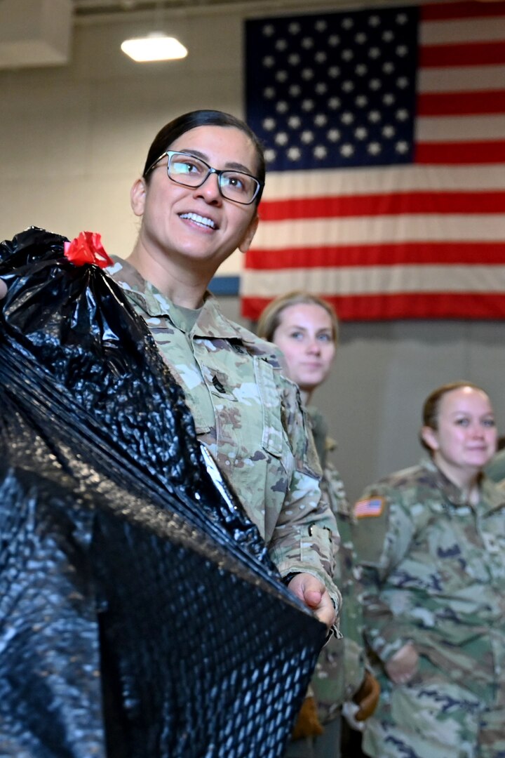 Sgt. 1st Class Lina Pineda of Joint Force Headquarters, New Hampshire Army National Guard, and fellow volunteers help load donated Christmas gifts onto a delivery truck Dec. 12, 2023, at the state military reservation in Concord.
