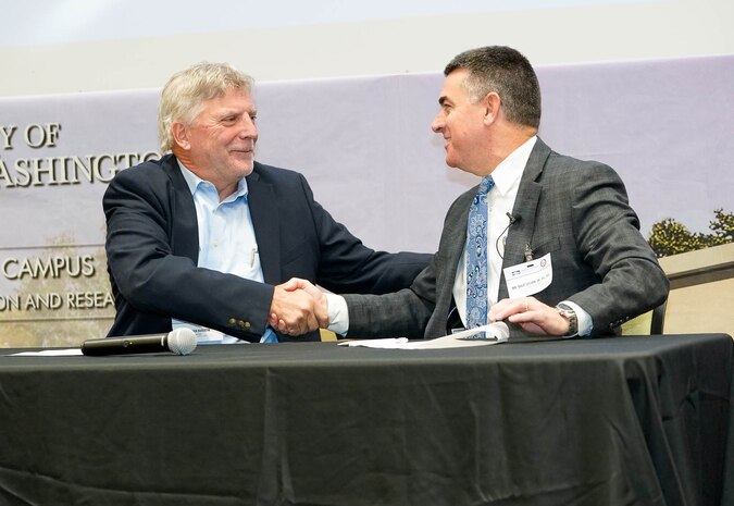 IMAGE: Fredericksburg Military Affairs Council Chairman Dr. John Burrow (left) shakes hands with Naval Surface Warfare Center Dahlgren Division Technical Director Dale Sisson Jr., P.E., SES, after the pair signed a Memorandum of Agreement at the end of the Potomac Tech Bridge kickoff event Dec. 12 at University of Mary Washington Dahlgren Campus.