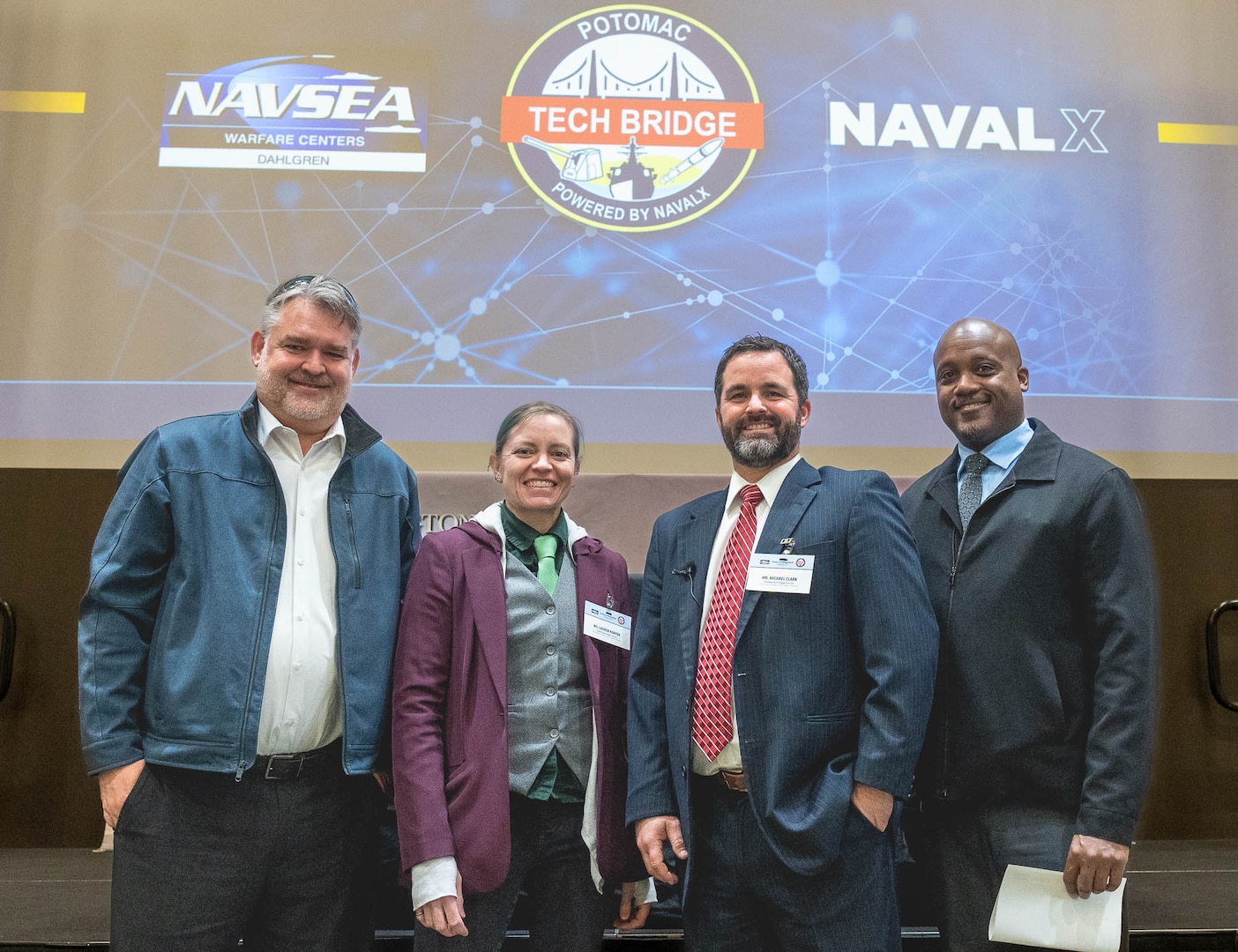 IMAGE: Naval Surface Warfare Center Dahlgren Division Potomac Tech Bridge Director Michael Clark (third from left) stands with Southern Maryland Tech Bridge Director Rick Tarr (left), Capital Tech Bridge Director Lauren Hanyhok (second from left) and Mid-Atlantic Tech Bridge Director Gerrold Walker (right) at the Potomac Tech Bridge kickoff event Dec. 12 at University of Mary Washington Dahlgren Campus.