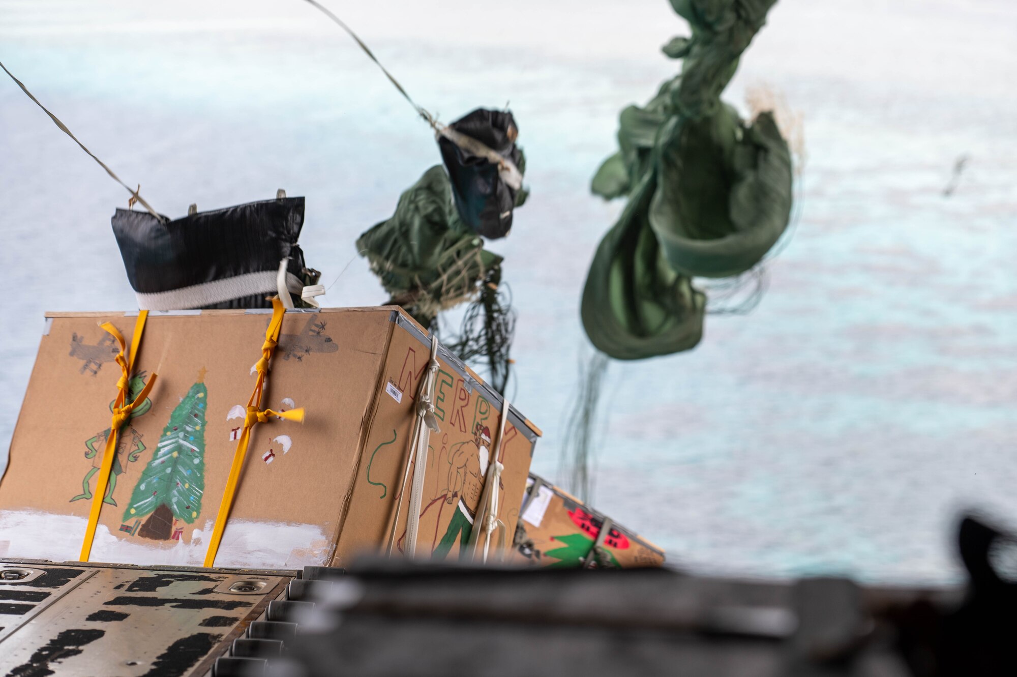 Supply bundles are dropped off of a C-130J Super Hercules during Operation Christmas Drop over the island Nama, Dec. 4, 2023. Operation Christmas Drop is the Department of Defense’s longest-running humanitarian airlift operation which consists of packaging and delivering donated supplies such as food, fishing equipment, school books, and clothing to more than 20,000 islanders across 56 remote islands throughout the Federated States of Micronesia and the Republic of Palau. (U.S. Air Force photo by Airman Allon Lapaix)