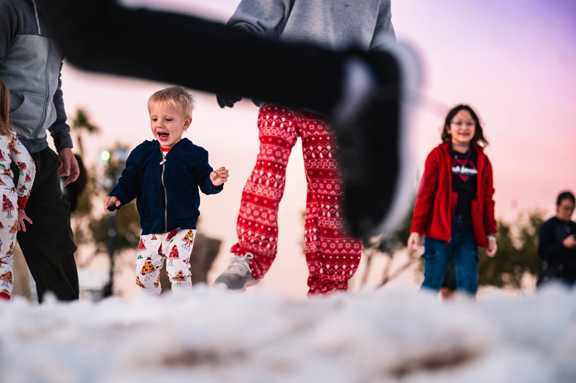 Military children play in the snow during the annual Holiday Magic event.