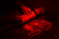 Members of Navy Medicine Readiness and Training Command (NMRTC) Charleston practice low light IV insertions during Fleet Readiness Operational Sustainment Training (FROST).