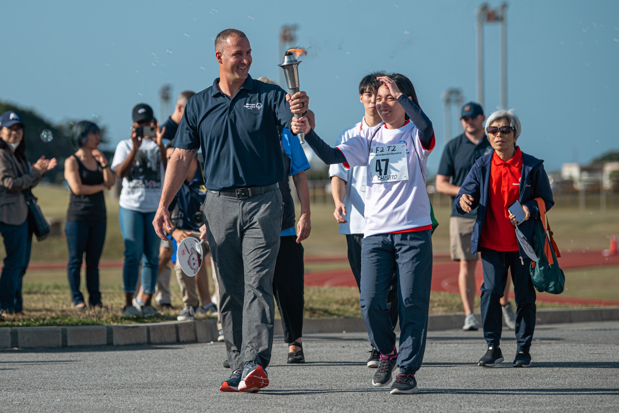 An Airman and athlete carry a torch.