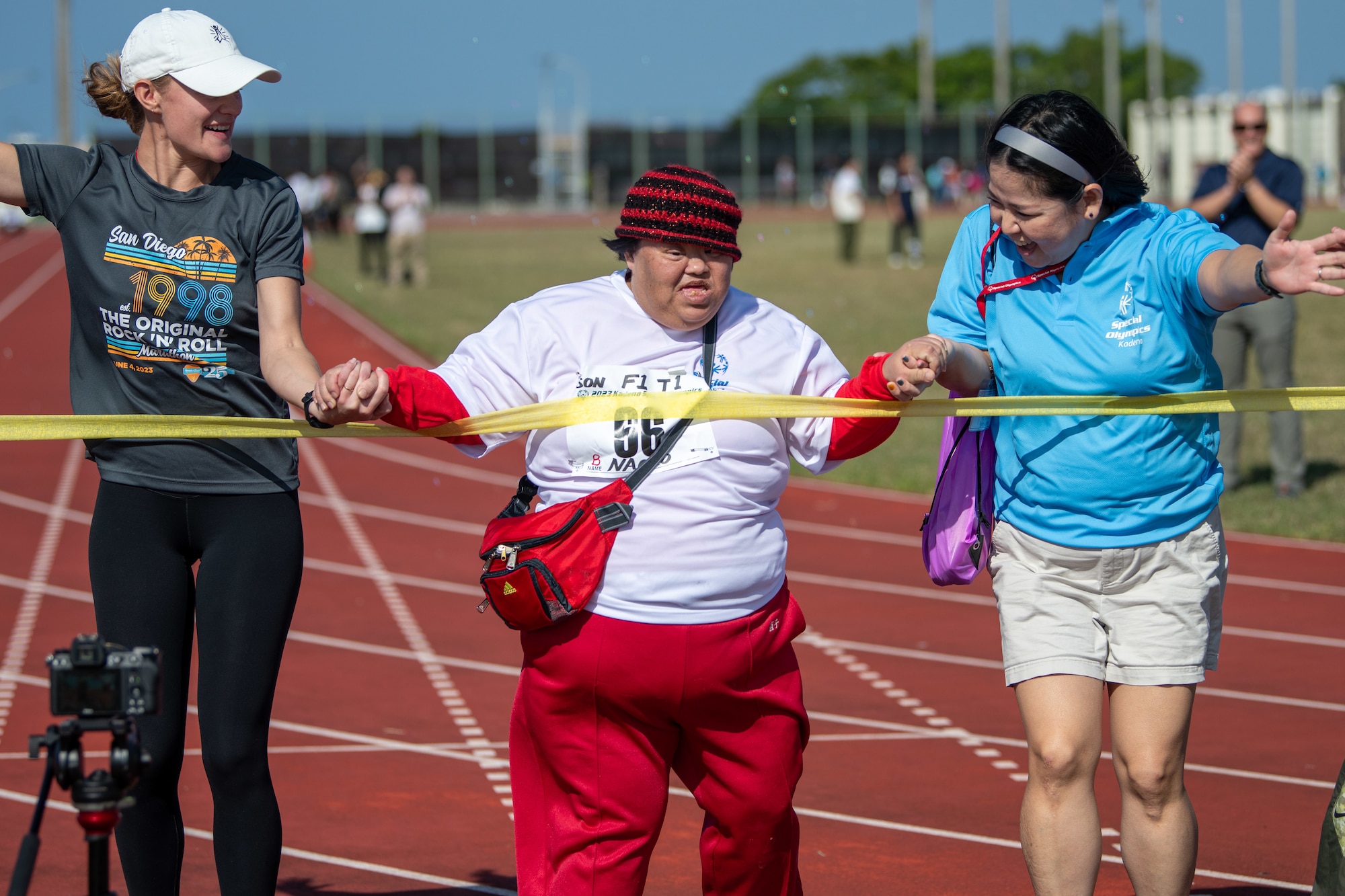 An athlete and volunteers race.