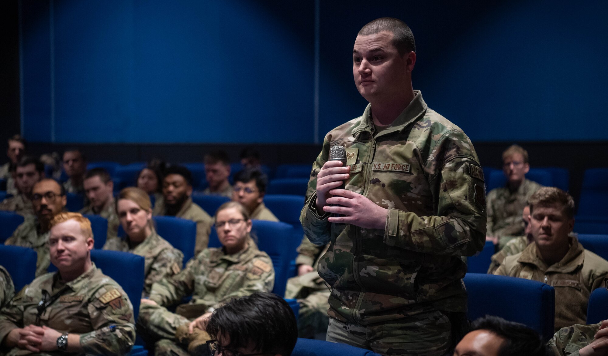 U.S. Air Force Staff Sgt. Paul Kirchler, 1st Combat Communications Squadron unit deployment manager, asks a question during an all-call with Lt. Gen. Leah G. Lauderback, intelligence, surveillance, reconnaissance; and cyber effects operations deputy chief of staff, at Ramstein Air Base, Germany, Dec. 7, 2023. During the all-call, Lauderback shared strategic level initiatives impacting cyber and ISR communities. (U.S. Air Force photo by Senior Airman Jared Lovett)