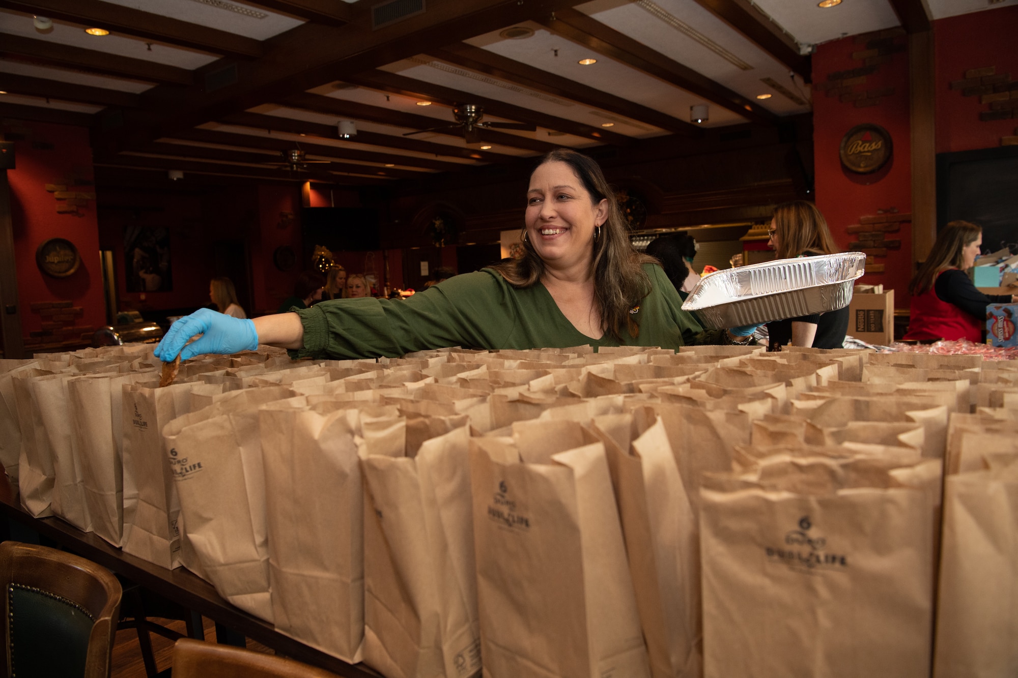Christi Ludwig, 2023 Operation Holiday Cheer and Airmen Cookie Drive volunteer, fills paper bags with homemade cookies