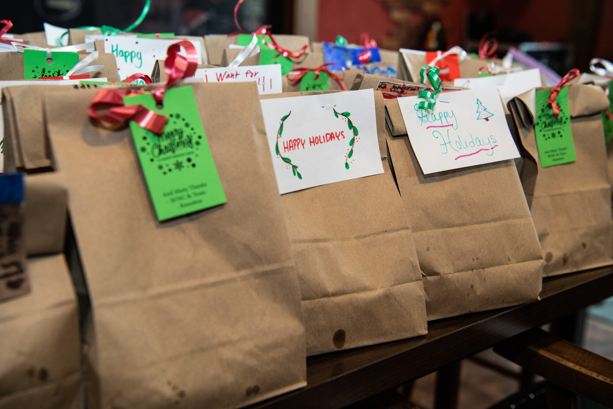 Decorated paper bags line a table