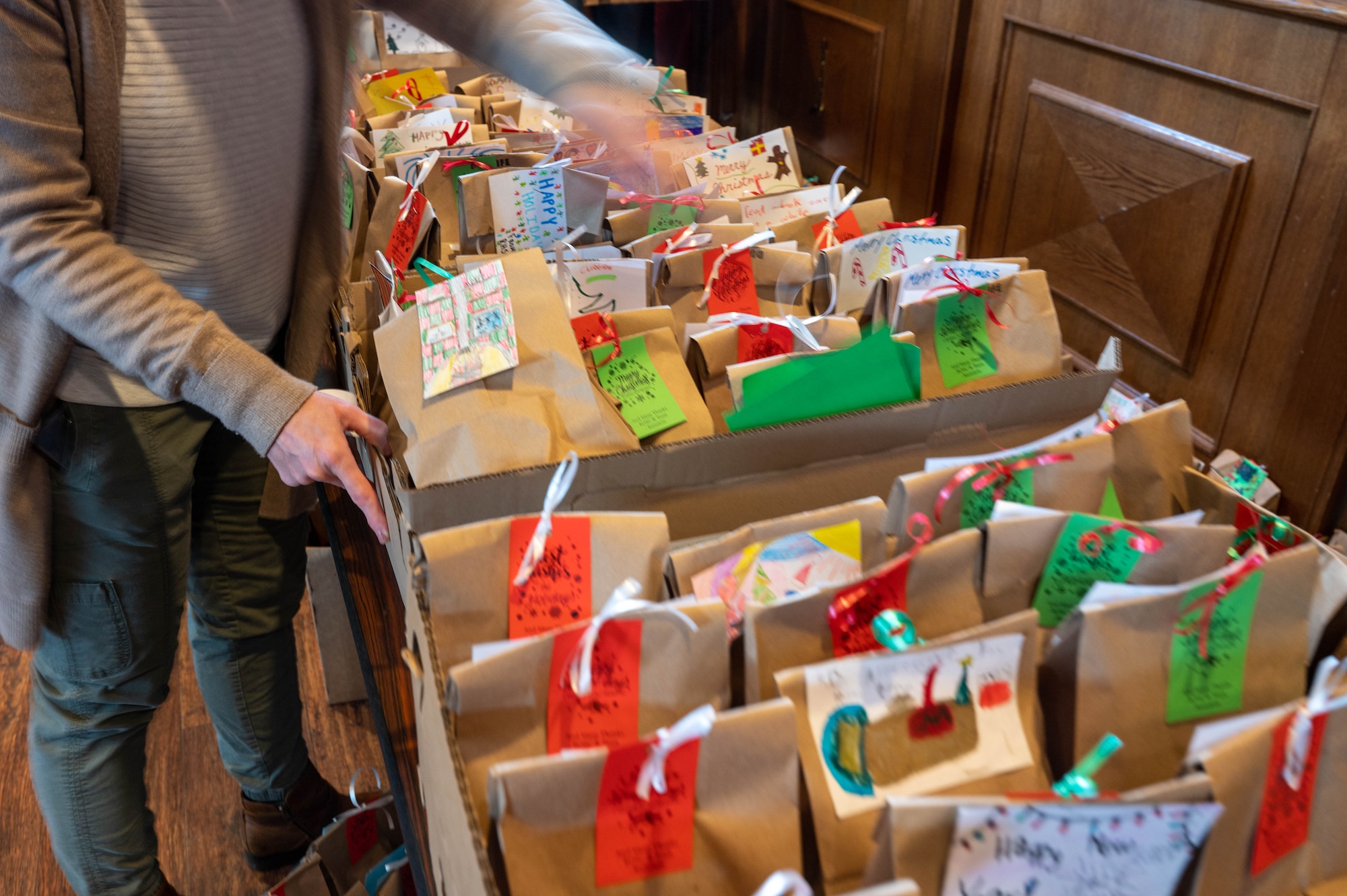 A volunteer sorts prepared gift bags for Airmen