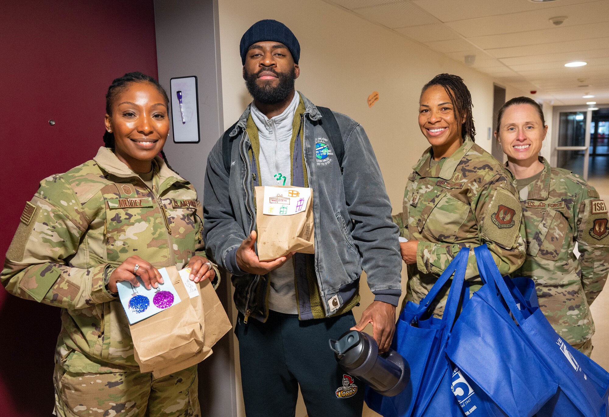 Leadership from the 86th Medical Group deliver cookies to a dorm Airman