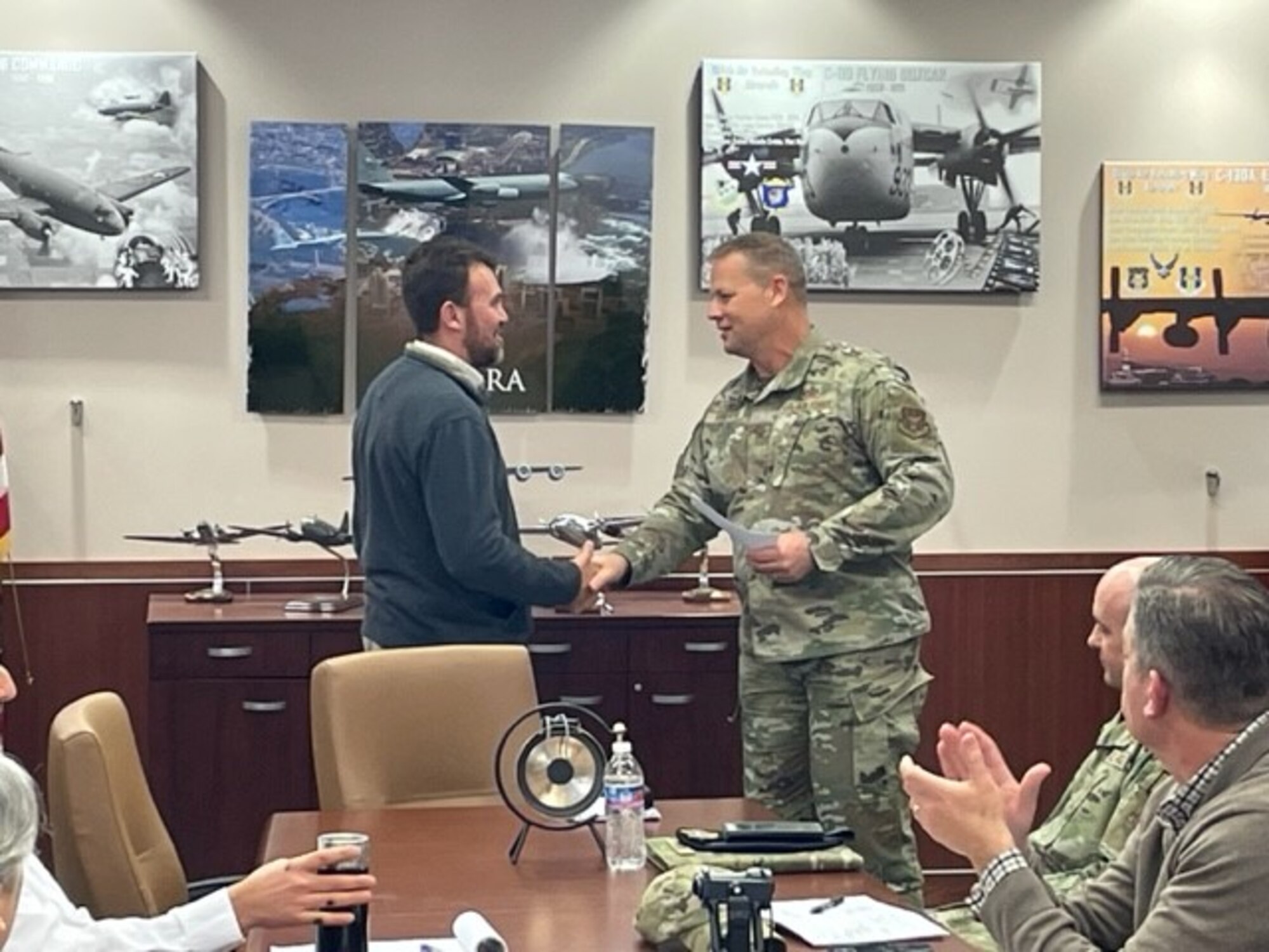 Mr. Jason Topick receives a coin from Col. Randall Roberts for superior performance in a recent inspection.