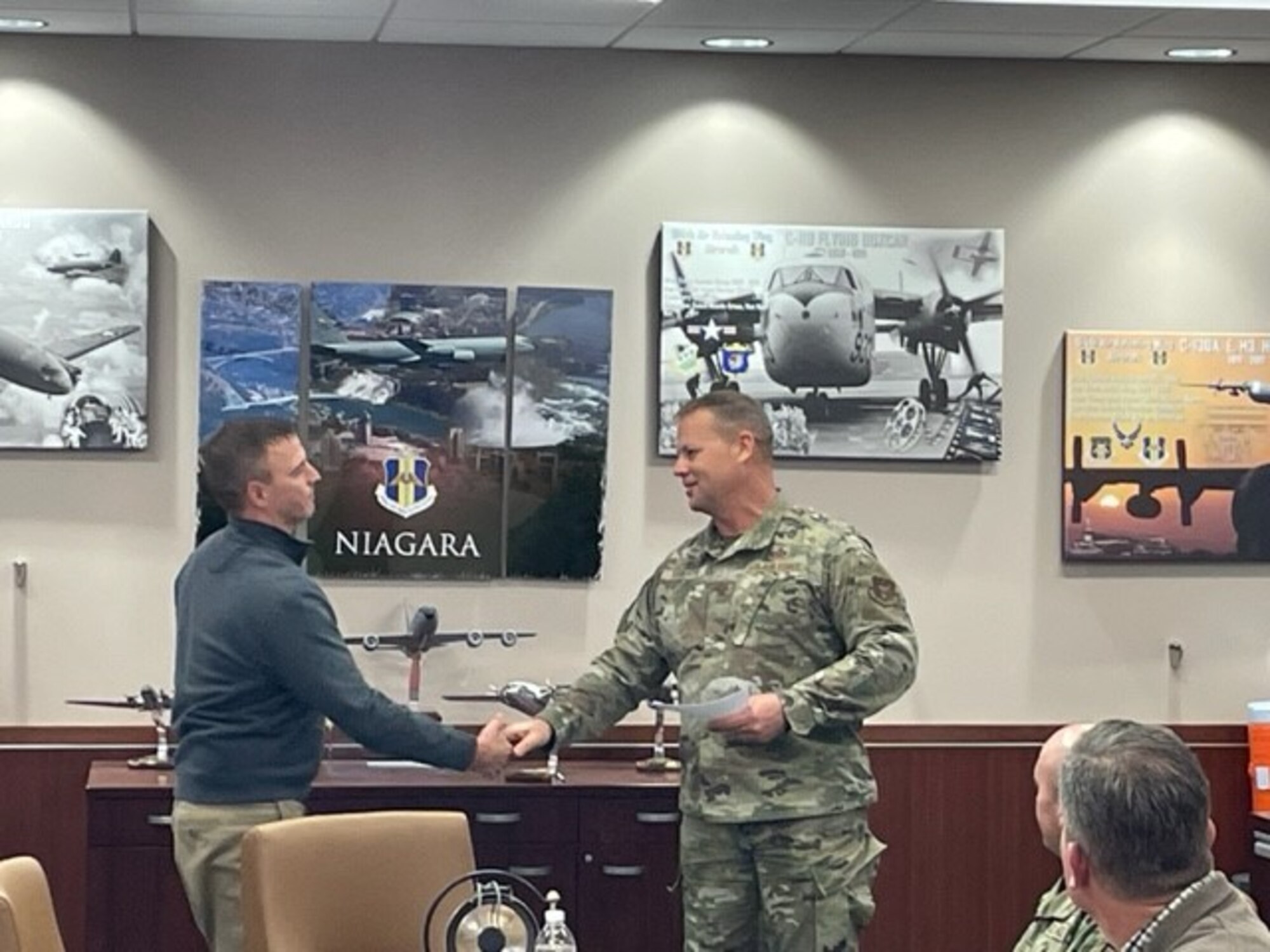 Mr. Dan Franklin receives a coin from Col. Randall Roberts for superior performance.