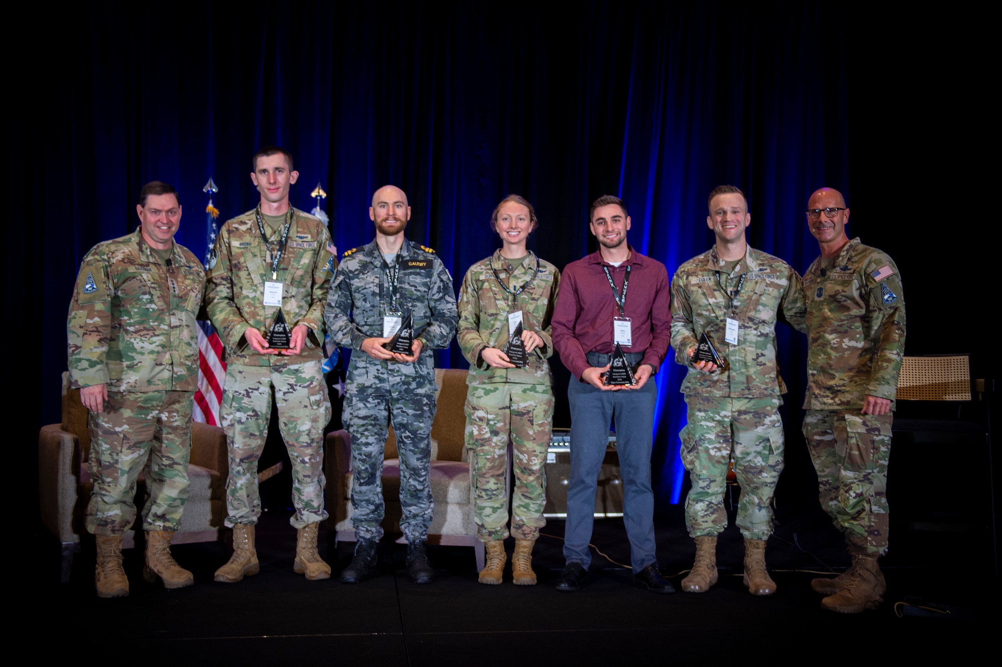 Chief of Space Operations U.S. Space Force Gen. Chance Saltzman and Chief Master Sgt. of the Space Force, Chief John Bentivegna, pose with the Guardian Arena winning team, Team Great Eight from Delta 8, at the Space Force Association Spacepower Conference  in Orlando, Fla., Dec. 12. From left: Saltzman, 1st Lt. Stephen Brown, Royal Australian Navy Lieutenant Angus Gaudry,  1st Lt. Sara Burton, Dillan Paschall, Capt. Alexander Colla and Bentivegna. (U.S. Air Force photo by Staff Sgt. Adam Shanks)