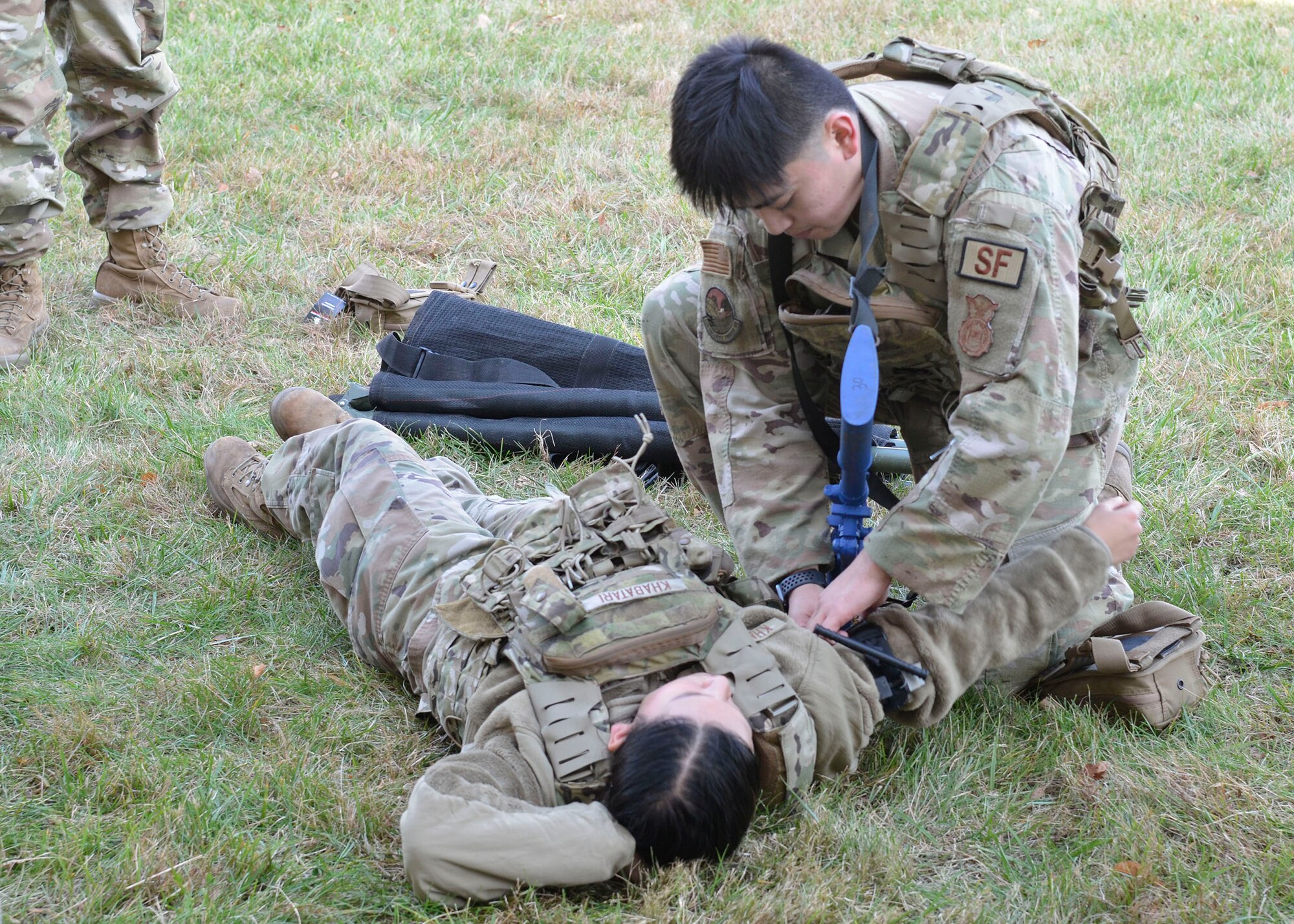 Senior Airman Adrian Dela Cruz, 445th Security Forces Squadron fire team member, applies a tourniquet on Airman Basic Puja Khabatari, 445th SFS fire team member, during a Tactical Combat Casualty Care course at Wright-Patterson Air Force Base, Ohio, Nov. 5, 2023. TCCC was developed by the U.S. Department of Defense’s Defense Health Agency Joint Trauma System to teach evidence based, life-saving techniques and strategies for providing the best trauma care on the battlefield. (U.S. Air Force photo/Staff Sgt. Ethan Spickler)