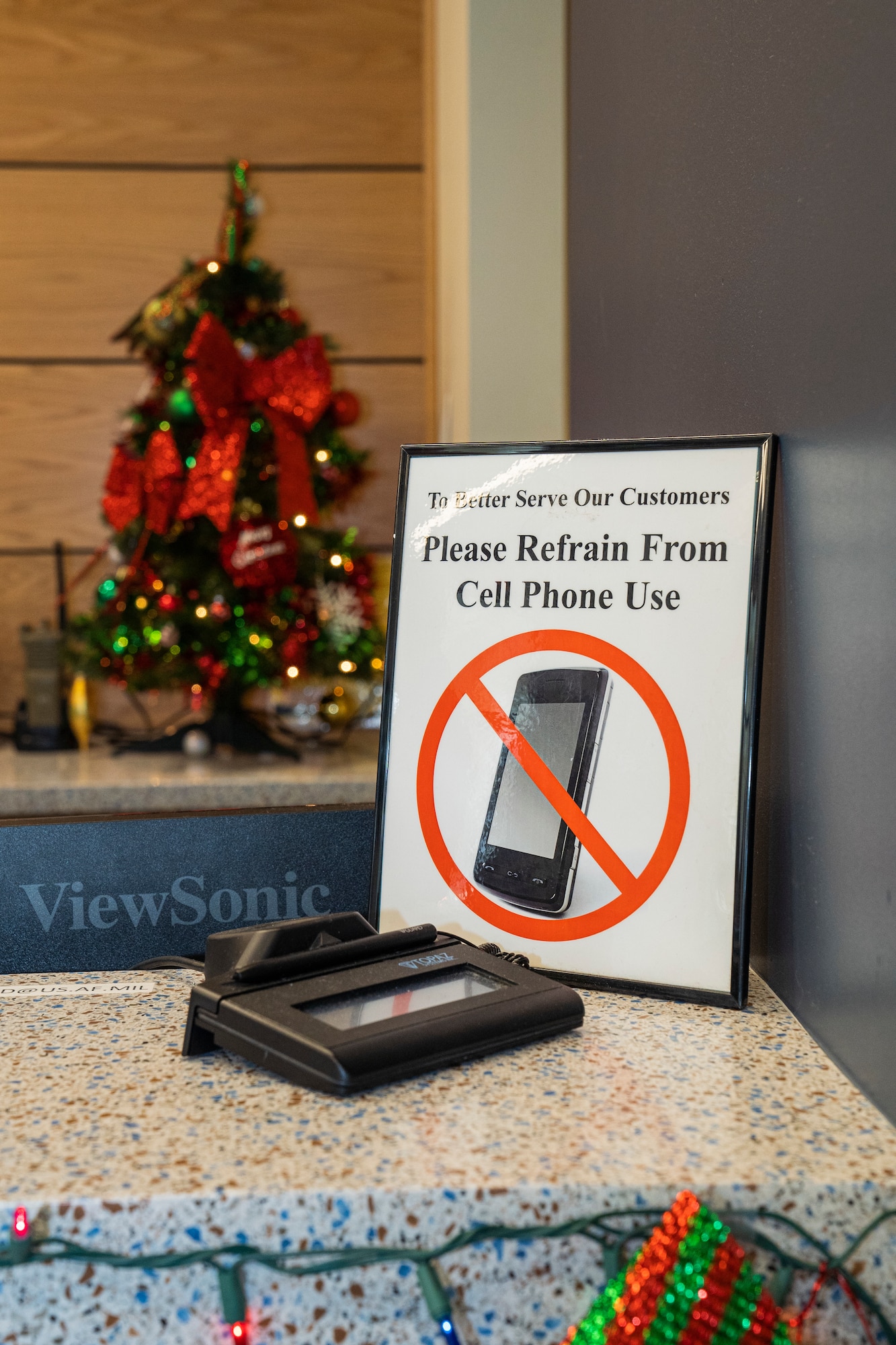 A sign prohibiting cell phone usage is displayed to prevent customers from using their devices while being serviced at the Division Street Gate Visitor’s Center on Keesler Air Force Base, Mississippi, Dec. 5, 2023.