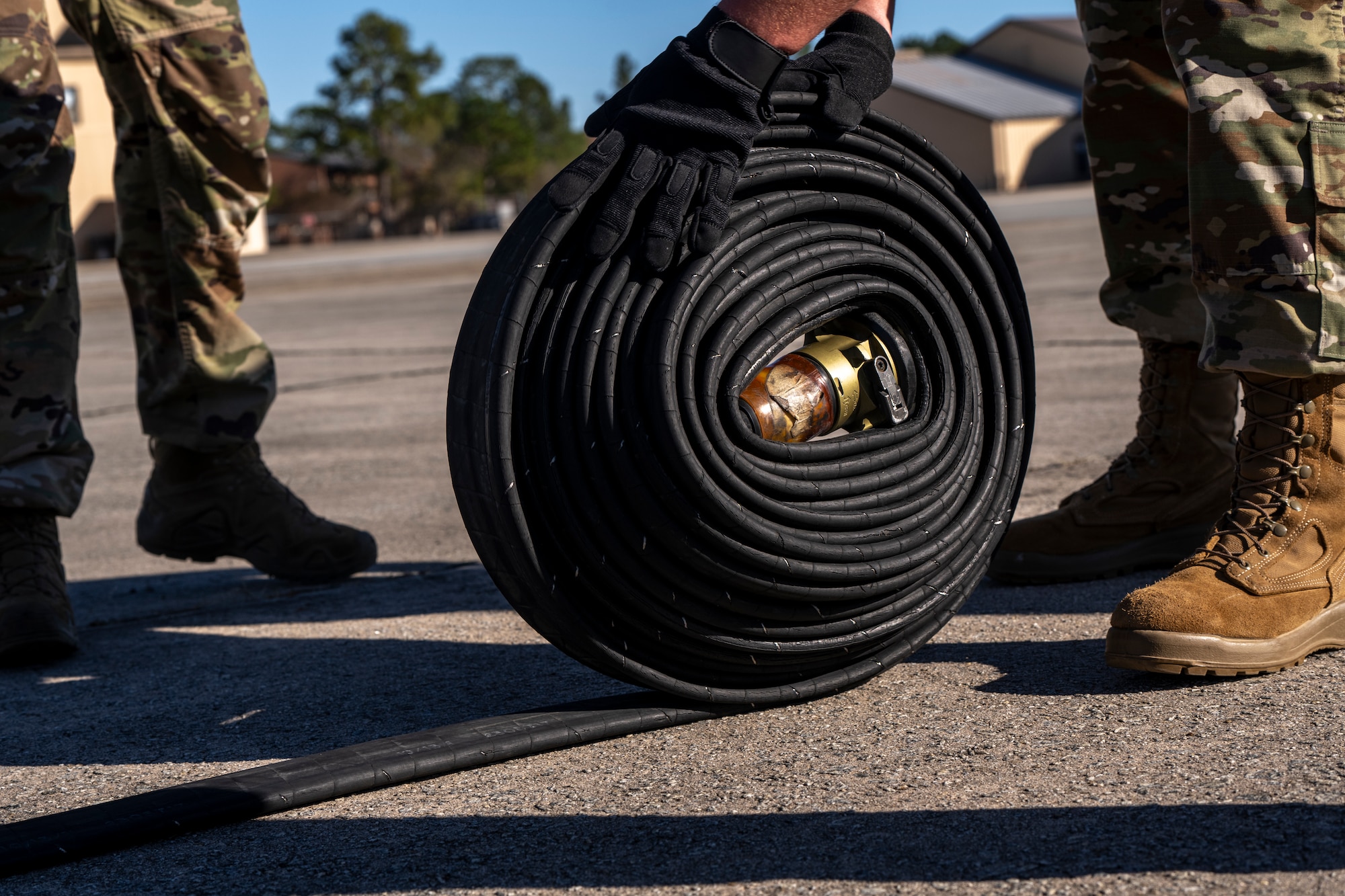 A U.S. Airman assigned to the 23rd Logistic Readiness Squadron rolls a hose