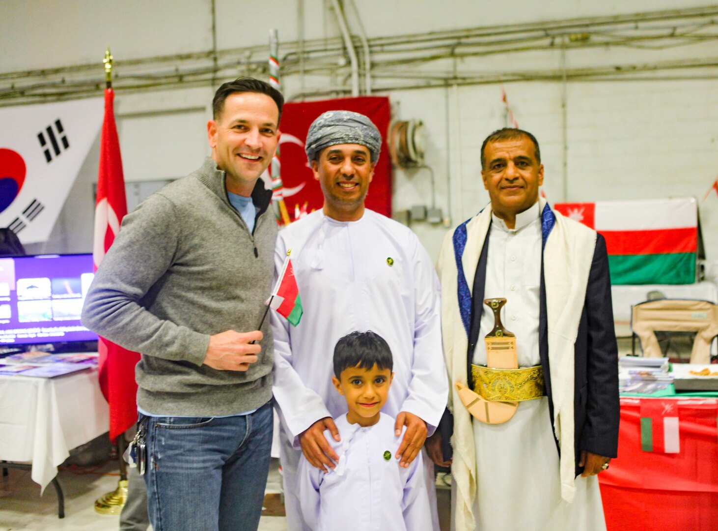 TAMPA, Fla. – A Saudi Senior National Representative (left) shows off an item during U.S. Central Command’s (CENTCOM) International Night, Dec. 07, 2023. International Night started in December 2004 as a winter holiday party for the Coalition members and families. This year, members of CENTCOM’s coalition countries displayed native customs and offered a taste of their traditional cuisines to guests. (U.S. Central Command Public Affairs photo by Maged Benjamin-Elias)