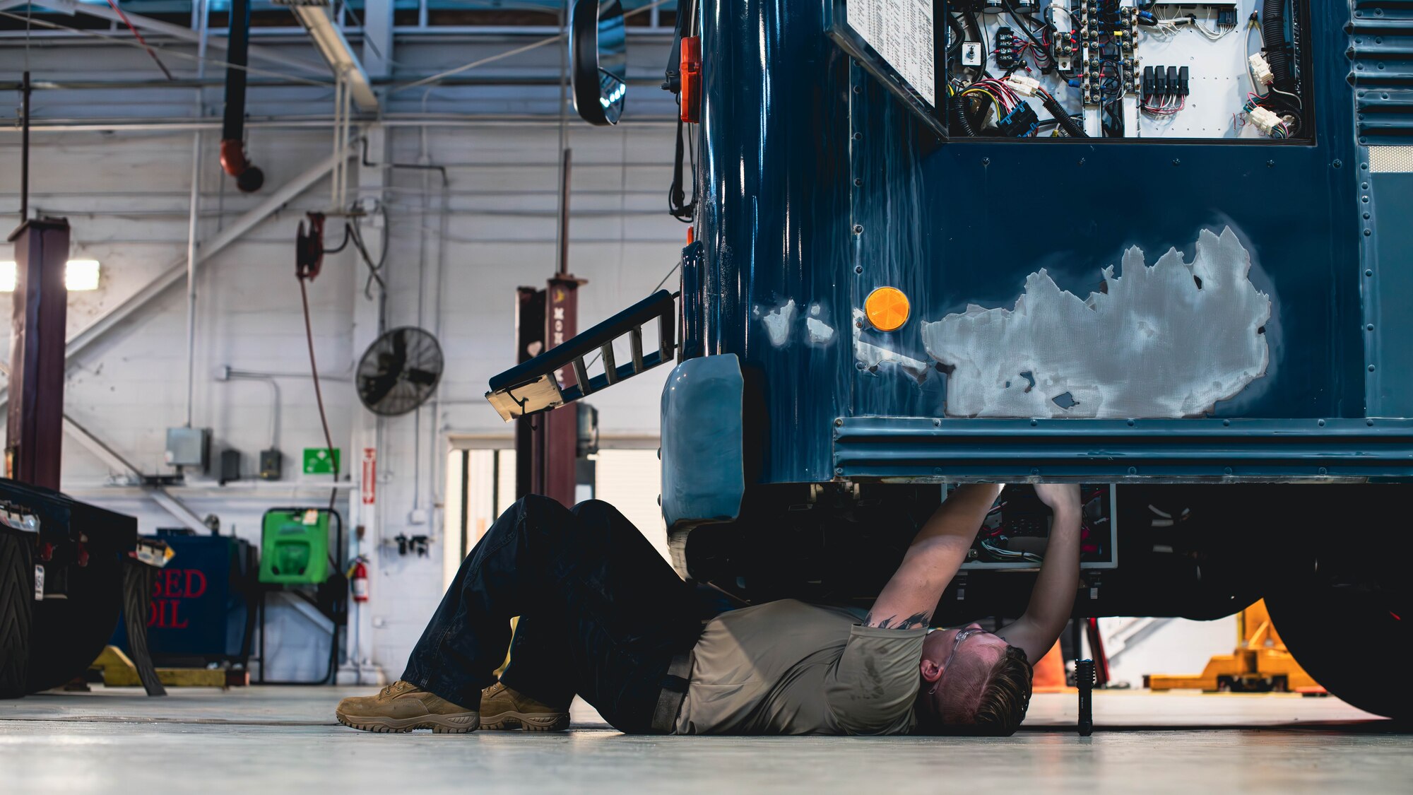 Airman works on a bus.