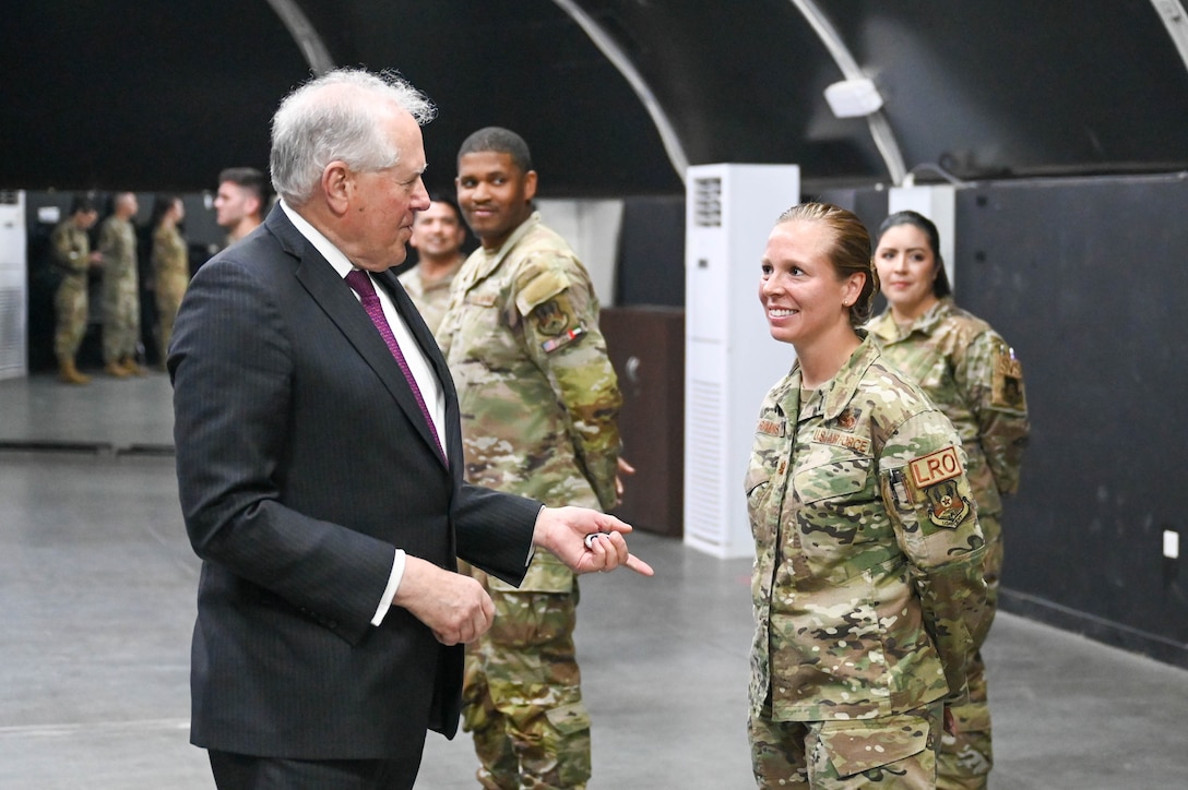 Secretary of the Air Force Frank Kendall coins an Airman at an undisclosed location in the U.S. Central Command area of responsibility