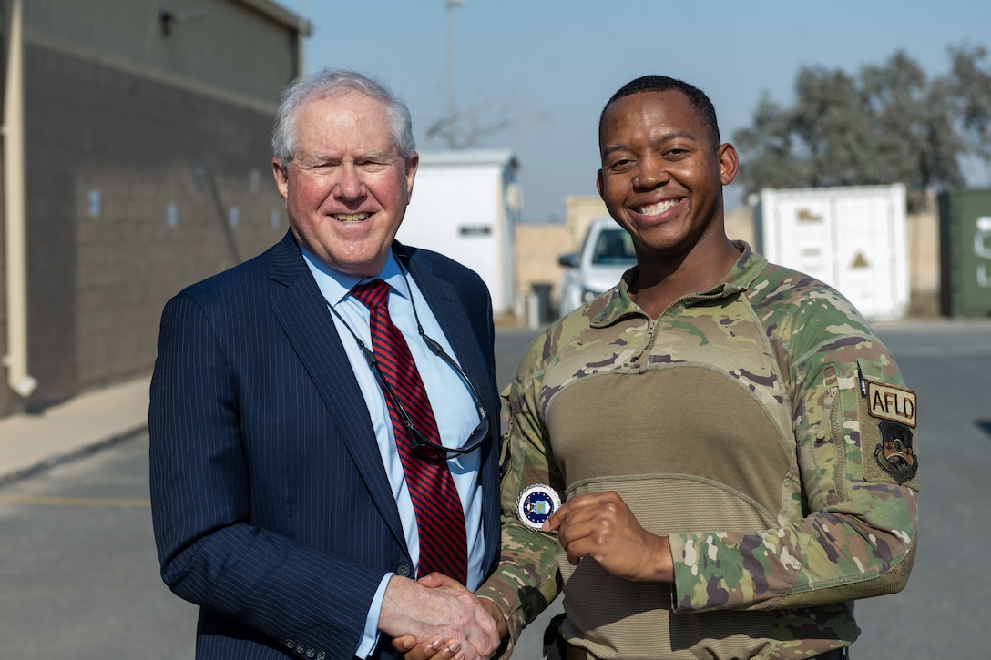 SECAF Frank Kendall coins U.S. Air Force Staff Sgt. Kahlil Cooke, an expeditionary operations support squadron wing airfield driving program manager, during a visit in an undisclosed location in the CENTCOM area of responsibility