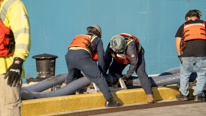 Personnel in support of Joint Task Force-Red Hill (JTF-RH) disconnect fuel lines from merchant tanker Yosemite Trader, completing the process of gravity draining the Red Hill Bulk Fuel Storage Facility (RHBFSF) flowable tank bottoms, at Joint Base Pearl Harbor-Hickam, Hawaii Dec. 7, 2023.