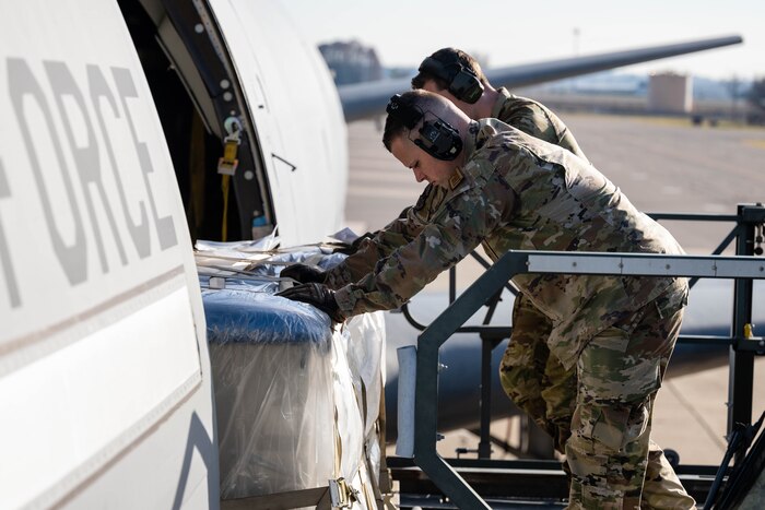 Airmen push cargo onto aircraft